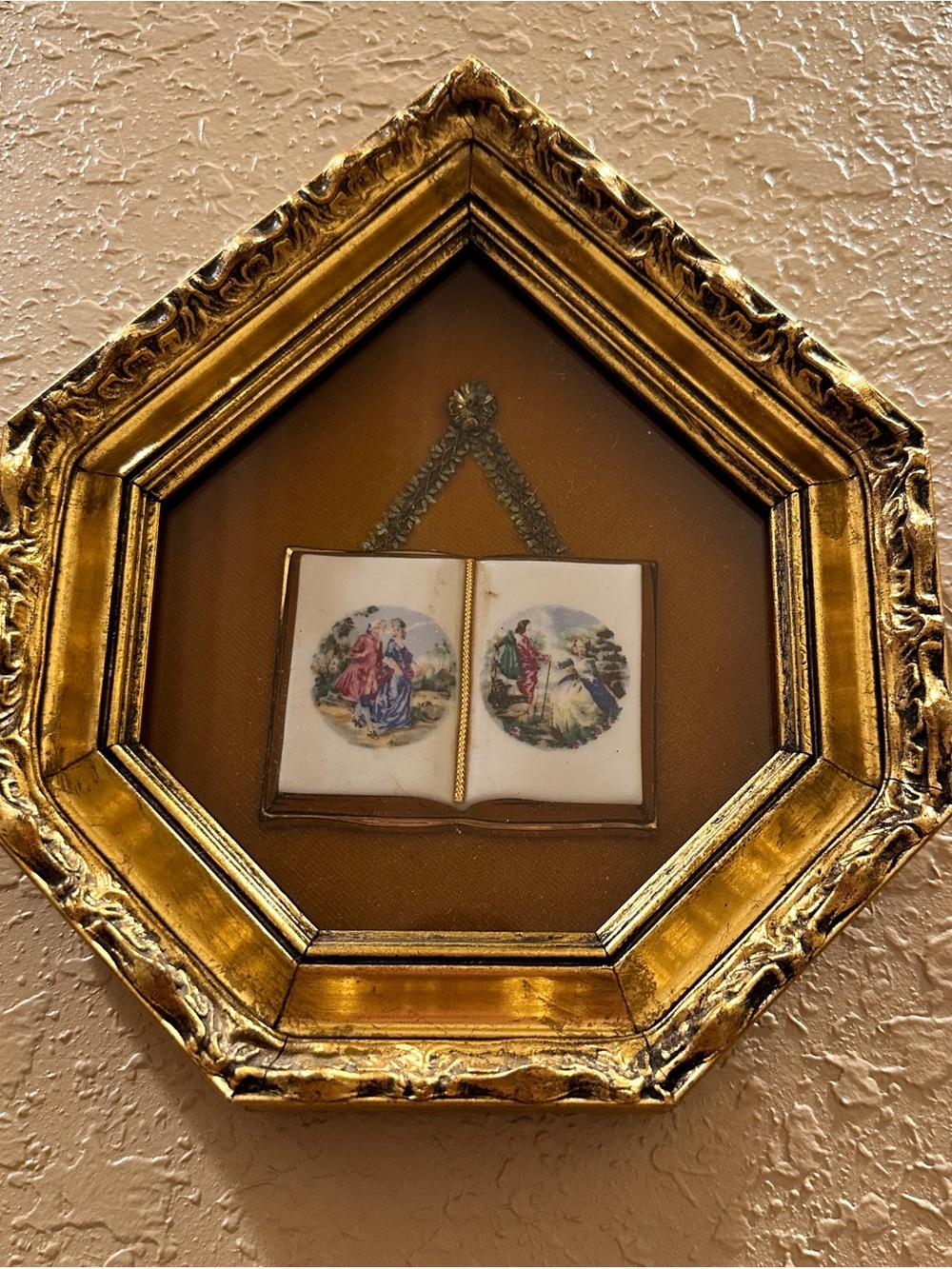 This is a vintage gold-framed shadow box featuring a small porcelain or ceramic